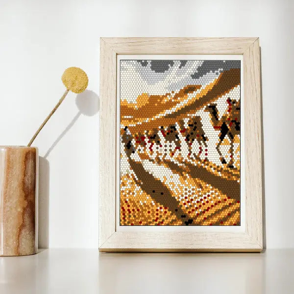 A framed mosaic artwork on a wooden surface, depicting Sahara Dessert, created with small hexagon shapes.