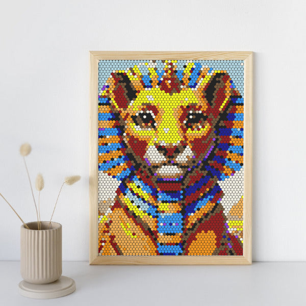 Colorful mosaic art of a lion in a wooden frame on a white wall.